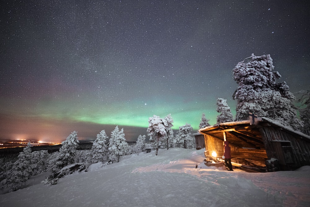 Aurores boréales, chalet sous la neige en Laponie