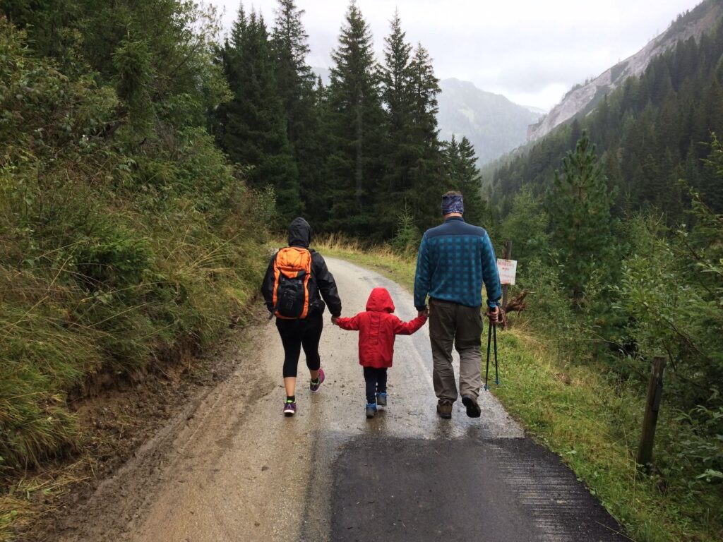 Famille marchant dans la nature sous la pluie