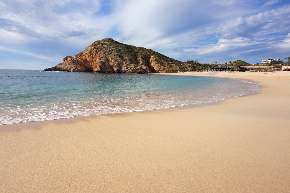 Plage de Santa Maria Beach; Cuba. Plage de sable blond, eau claire et montagne en fond