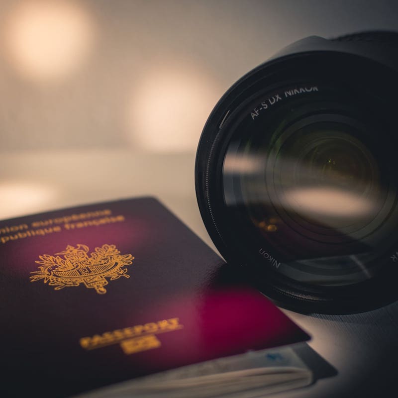 passeport français à côté d'un appareil photo