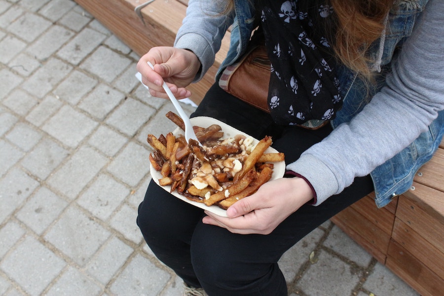 Dégustation d'une poutine, plat typique de Montréal, Canada